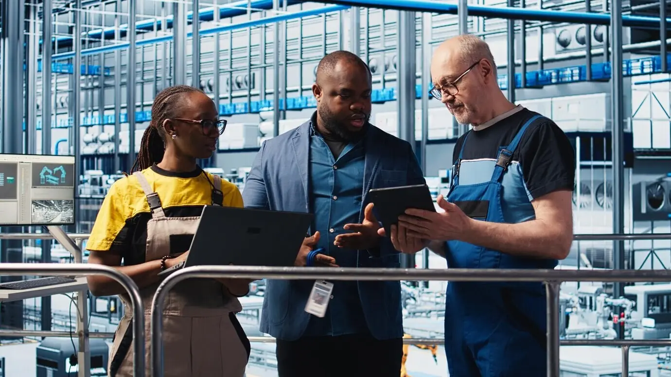 Руководитель контролирует работу инженеров на заводе Индустрии 4.0 по производству солнечных панелей для сокращения простоев.